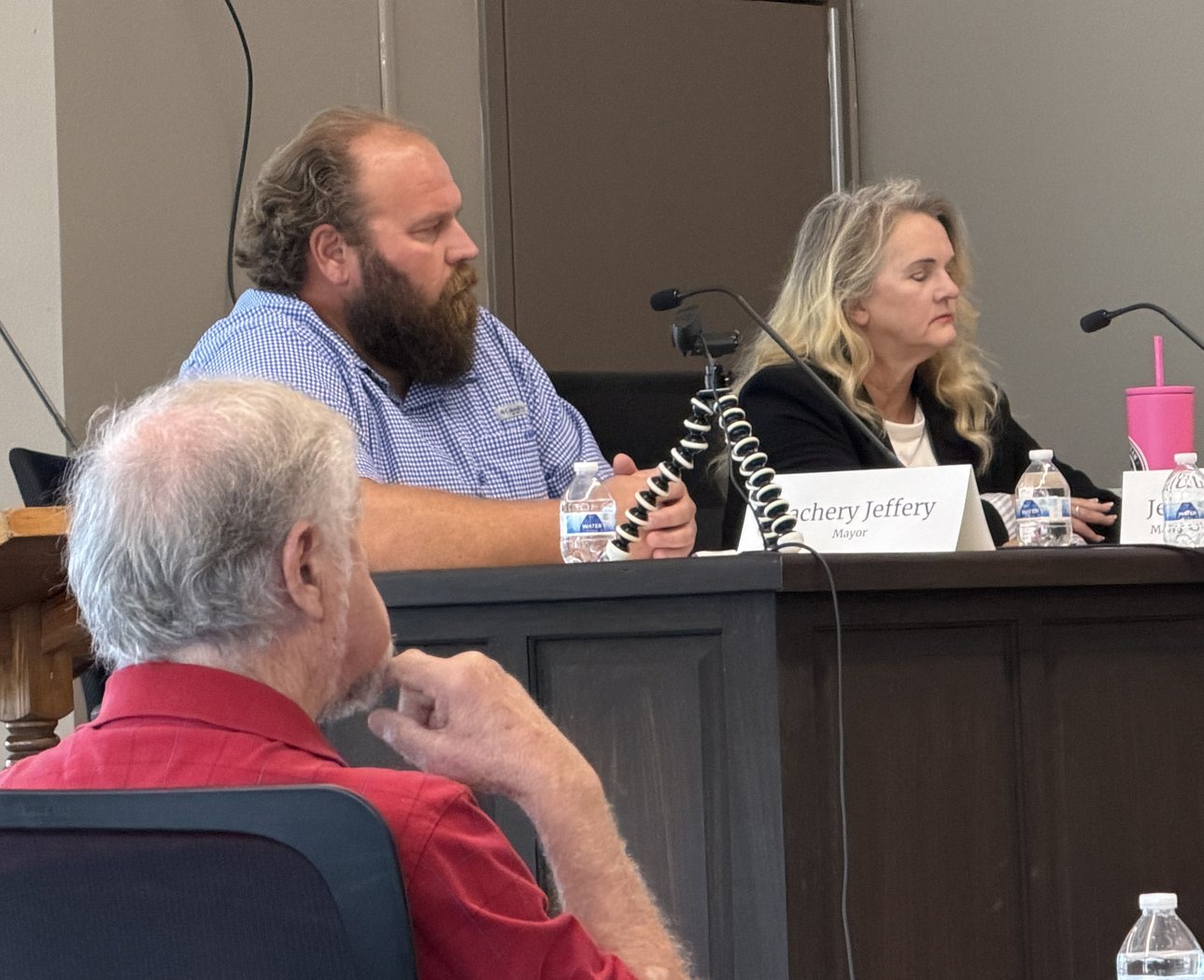 Zach Jeffery at the candidate town hall, listening to a resident asking a question